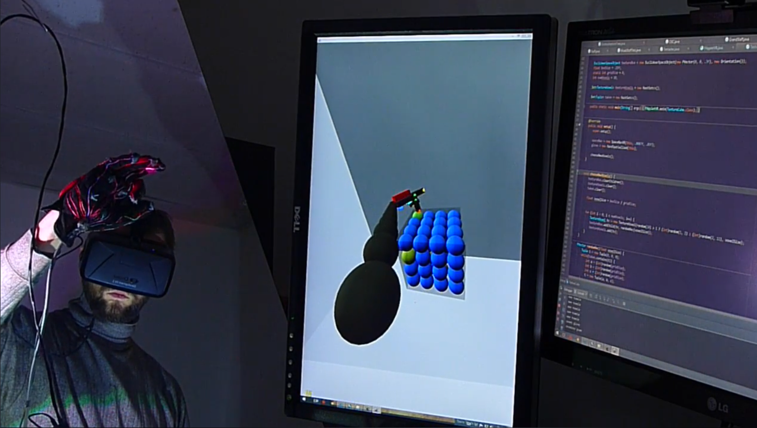 VR data glove prototype beside monitors showing a virtual hand interaction demo and code